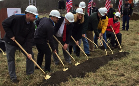 a group of supporters breaks ground at a smart home site.